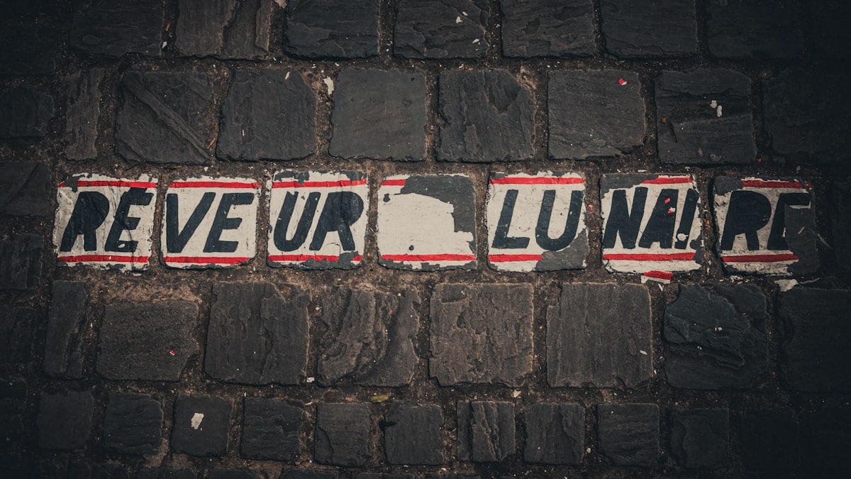 a street sign on a brick wall that says reveur lunaart